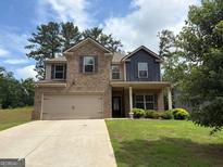 Charming two-story brick home featuring a two-car garage and a well-manicured front lawn at 1001 Hartwell Rd, Locust Grove, GA 30248