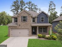 Charming two-story home with a brick facade, attached garage, and well-manicured lawn at 1001 Hartwell Rd, Locust Grove, GA 30248