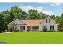 Charming single-story home with a manicured lawn and traditional architectural details at 1422 New Holland Cir, Mcdonough, GA 30252