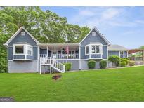 Charming blue house featuring a covered porch, bay windows, and a lush green lawn at 4002 Joshua Ln, Douglasville, GA 30135