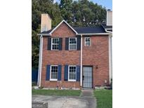 Charming two-story brick home with a well-maintained front yard and a secure metal gate at 990 Hickory Bend Rd, Atlanta, GA 30349