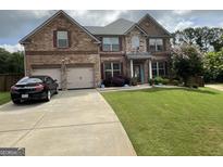 Charming two-story brick home with a well-manicured lawn and a two-car garage at 1141 Norsworthy Ml, Hampton, GA 30228