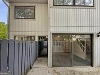 Charming townhouse featuring a gray exterior, inviting front door, and sliding glass doors at 1480 D Ne Pine Log Rd # D, Conyers, GA 30012