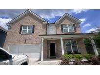 Charming two-story brick home with a two-car garage and a welcoming front porch at 3750 Richmond Bnd, Lithonia, GA 30038