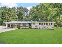 Charming one-story home with a long driveway and well-manicured lawn and front bushes at 3403 Linda Dr, Lithia Springs, GA 30122