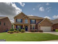 Charming brick two-story home with manicured lawn and inviting curb appeal on a sunny day at 312 Relative Trl, Mcdonough, GA 30253