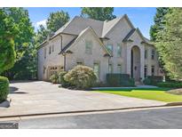 Stunning brick home boasts an attached garage, long driveway, and lush landscaping at 8430 Merion Drive Dr, Duluth, GA 30097