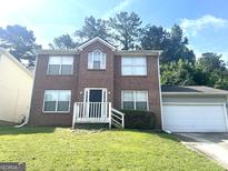 Charming brick two-story home with an attached garage and a well-maintained lawn at 755 Kilkenny Cir, Lithonia, GA 30058