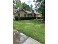 Charming single-story home features a well-manicured front yard and a classic brick chimney at 8440 Winston Way, Jonesboro, GA 30236