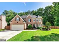 Charming brick home featuring a manicured lawn, two-car garage, and inviting front entrance at 1605 Cascade Overlook, Peachtree City, GA 30269