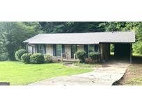 Charming brick home with mature landscaping, gray roof and attached carport at 341 Pineland Sw Rd, Mableton, GA 30126
