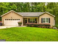 Charming single-story home with a well-maintained lawn, attached garage, and flowering bushes at 107 Trisha Ln, Grantville, GA 30220