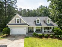 Charming home with a two-car garage, welcoming front porch, and well-manicured lawn at 2565 Aaron Ct, Loganville, GA 30052