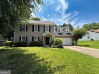 Charming two-story home featuring black shutters, a two-car garage, and a lush green lawn at 5156 Allison Way, Sugar Hill, GA 30518