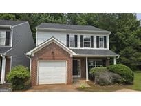 Charming two-story home featuring a brick facade, attached garage, and a well-maintained front yard with lush landscaping at 2378 Charleston Se Pt, Atlanta, GA 30316