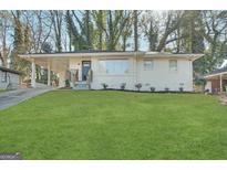 Charming, renovated single-story home with a large, well-maintained front lawn and inviting curb appeal at 3153 Bellgreen Way, Decatur, GA 30032