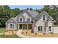 Beautiful two-story home with a stone accent, an American flag, and landscaped front yard at 140 Olivia Ct, Fayetteville, GA 30215