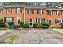 Charming brick townhomes featuring black shutters, well-kept landscaping, and private driveways at 1099 Westfield Se Trce, Smyrna, GA 30082