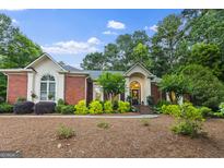 Charming brick home featuring a meticulously landscaped front yard and welcoming entrance at 107 Calloway Xing, Peachtree City, GA 30269