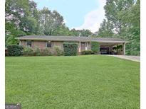 Charming brick home with a well-manicured front yard and covered parking at 260 Sharon Dr, Fayetteville, GA 30214