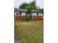 Charming one-story home featuring a brick facade, well-tended lawn and mature trees at 250 Jonesboro Rd, Jonesboro, GA 30236