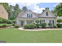 Charming home featuring manicured landscaping, green lawn, and classic white facade at 332 Aster Ridge Trl, Peachtree City, GA 30269