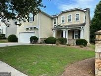 Charming two-story home with manicured lawn and attached two-car garage at 6131 Sparkling Cove Ln, Buford, GA 30518