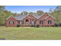 Charming single-story brick home with a well-manicured lawn and mature landscaping, perfect for curb appeal at 3530 Highway 81 W, Hampton, GA 30228