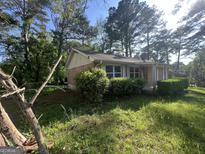 Charming brick home with well-kept bushes and a neatly manicured lawn at 7128 Lady Heidi Ct, Jonesboro, GA 30236