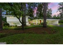 Charming exterior of home with lush landscaping and inviting front porch with wooded trees at 2944 Braithwood Ne, Atlanta, GA 30345
