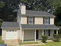 Charming two-story home featuring neutral siding, dark shutters, and a cozy front porch at 756 Glenshire Ct, Riverdale, GA 30274