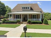Charming home featuring a welcoming front porch and meticulously landscaped lawn and beautiful plantings at 150 Campaign Trl, Fayetteville, GA 30214