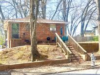 Brick home with wooden staircase to entrance and lush landscaping at 857 Grant Se Ter, Atlanta, GA 30315