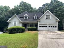 Charming home with a well-manicured lawn and a two-car garage, surrounded by lush greenery at 71 Southern Golf Ct, Fayetteville, GA 30215