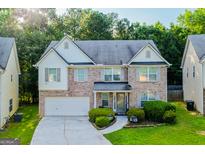 Charming two-story home with a brick facade, well-manicured lawn, and an attached two-car garage at 4613 Beau Point Ct, Snellville, GA 30039