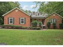 Charming brick home featuring a well-manicured lawn and classic architectural details at 140 Alford Dr, Fayetteville, GA 30215