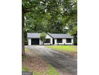 Charming ranch-style home featuring a black two-car garage and a well-manicured lawn at 168 Park Ln, Dallas, GA 30157