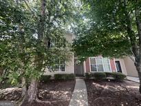Charming two-story home with a pathway and mature trees in the front yard at 160 Odyssey Turn, Conyers, GA 30012