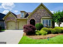 Charming home with stone accents, arched entryway, well-manicured lawn, and a two-car garage at 545 Grand Teton Cir, Fayetteville, GA 30215