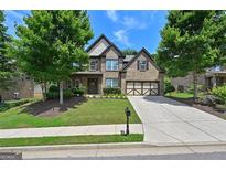 Inviting two-story brick home with a well-kept lawn, mature trees, and a spacious driveway at 5825 Trailwood Ct, Suwanee, GA 30024