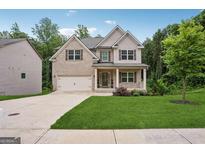 Charming two-story home with brick and siding, a well-manicured lawn, and an attached two-car garage at 5662 Valley Loop, Fairburn, GA 30213