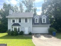 Charming two-story home with a well-maintained lawn and attached two-car garage, offering curb appeal at 6650 Smoke Ridge, Atlanta, GA 30349