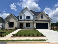 Charming two-story home featuring a brick and siding exterior, manicured lawn, and a black two-car garage door at 321 Ruffian Cir # 70, Peachtree City, GA 30269