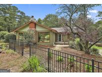 Charming single-story home with a stone chimney, large windows, and a well-maintained front yard at 6220 Petersburg Rd, Fairburn, GA 30213