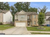 Charming two-story home with brick and siding, a well-maintained lawn, and an attached two-car garage at 2004 Brittlebank Ln, Lawrenceville, GA 30043