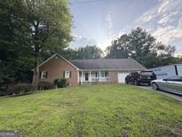 Charming brick ranch home with a well-manicured lawn and inviting front porch at 2119 Amherst Se Trl, Conyers, GA 30094
