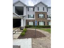 The apartment building features a mix of grey siding and brick, with black shutters and a well-maintained lawn at 14104 Fairington Ridge Cir, Lithonia, GA 30038