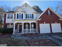 Charming two-story home with brick and siding, well-manicured lawn, and attached two-car garage at 5725 Lake Windsor Pkwy, Buford, GA 30518