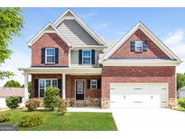 Charming two-story brick home with a well-manicured lawn and a two-car garage at 335 Autumn Bluff Dr, Lawrenceville, GA 30044
