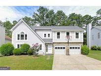 Charming two-story home with a well-manicured lawn, two-car garage, and a basketball hoop above the garage at 4180 Pineset Dr, Alpharetta, GA 30022